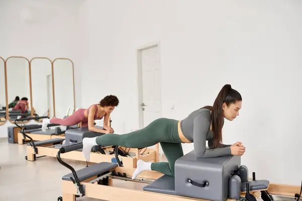 Atractivas mujeres en ropa deportiva durante pilates en un gimnasio juntas. - foto de stock