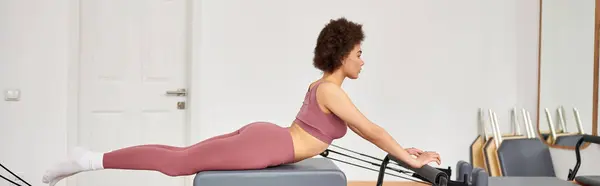 Mulher atraente exercitando-se durante uma aula de pilates. — Fotografia de Stock