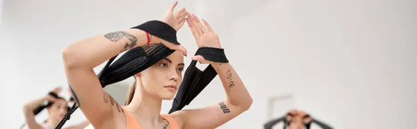 A pretty, sporty woman with her hands in the air during a pilates lesson. — Stock Photo