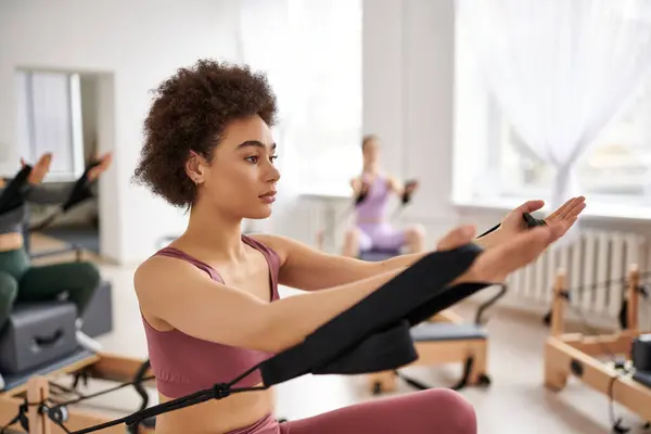 A group of pretty sporty women in a gym doing exercises during a pilates lesson. — Stock Photo
