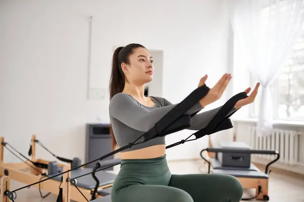 Séduisante femme en tenue confortable exerçant activement sur pilates leçon. — Photo de stock
