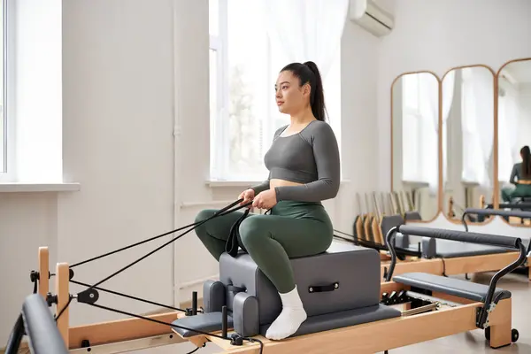 Attractive woman in cozy attire actively exercising on pilates lesson. — Stock Photo