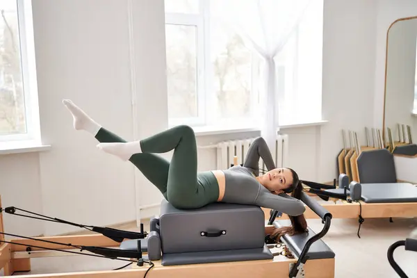 Athletic woman in cozy attire actively exercising on pilates lesson. — Stock Photo