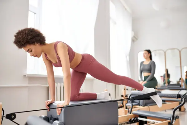 Beautiful women in cozy attire practicing pilates in a gym together. — Stock Photo