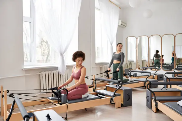 Gruppe ziemlich sportlicher Frauen bei einer dynamischen Pilates-Session im Fitnessstudio. — Stockfoto