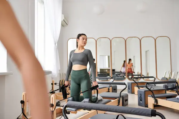 Good looking women gracefully practicing pilates in a gym together. — Stock Photo