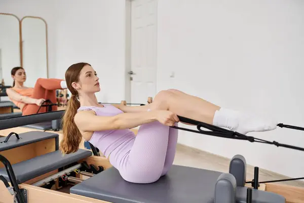 Attraktive Frauen üben anmutig Pilates in einem Fitnessstudio zusammen. — Stockfoto