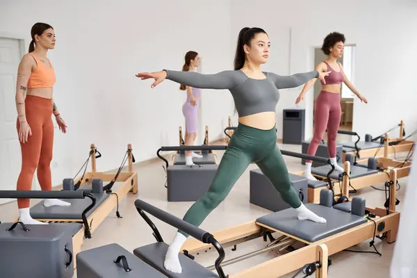 Eine vielfältige Gruppe sportlicher Frauen in einem dynamischen Pilates-Kurs voller Energie und Bewegung. — Stockfoto
