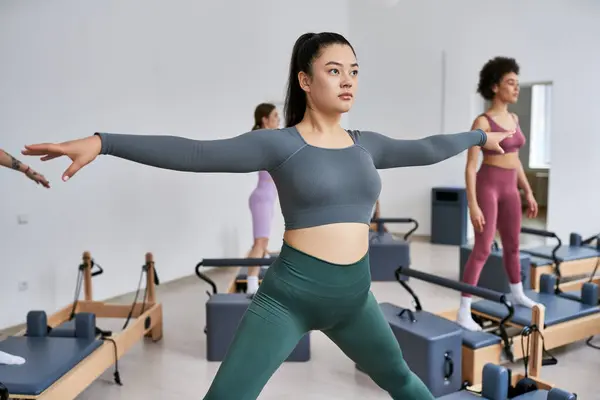 A group of pretty sporty women engaging in a lively pilates class. — Stock Photo