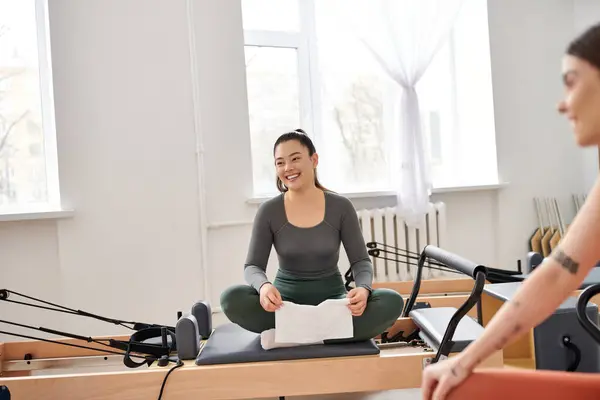 Femmes attrayantes prenant une pause pendant les cours de pilates dans la salle de gym. — Photo de stock