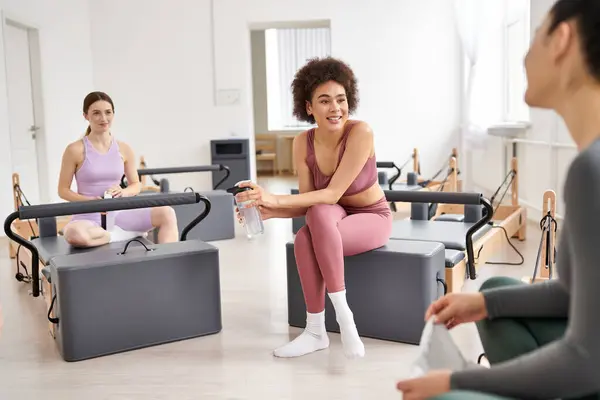 Mulheres atraentes passar o tempo juntos na aula de pilates no ginásio, relaxante. — Fotografia de Stock