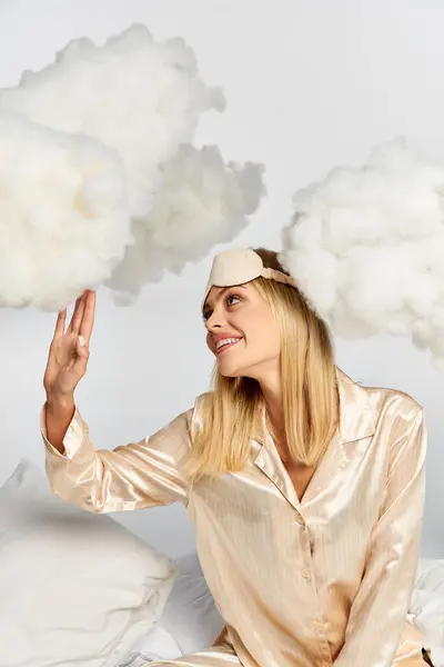 Appealing woman in cozy pyjamas surrounded by clouds. — Stock Photo