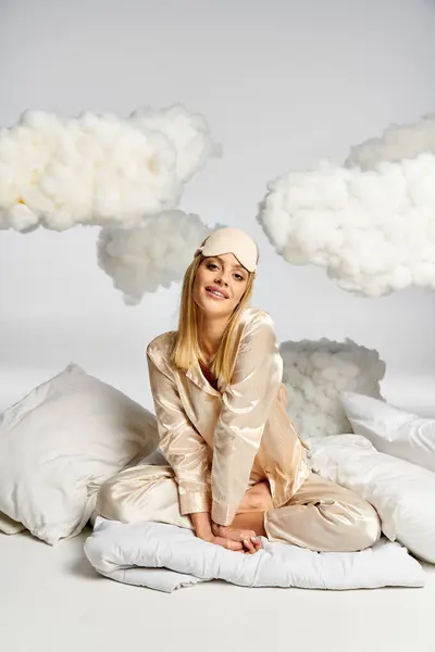 Hübsche Frau im kuscheligen Pyjama umgeben von Wolken. — Stockfoto