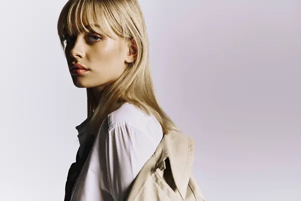 A stylish woman with blonde hair posing in an elegant white shirt. — Stock Photo
