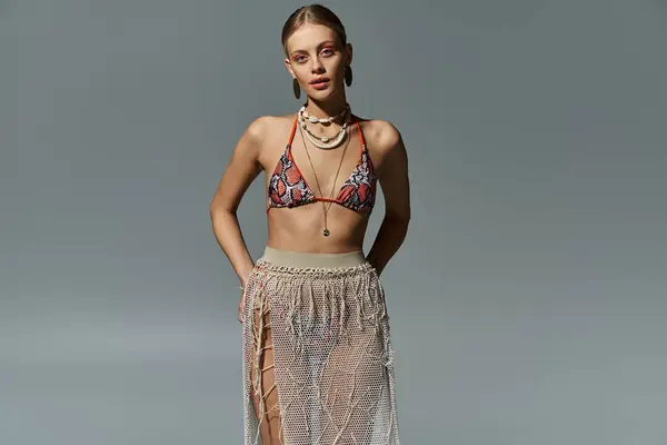 Femme élégante avec des poses de cheveux blonds en maillots de bain et jupe à la mode. — Photo de stock