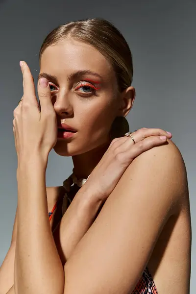 Donna elegante con i capelli biondi colpisce una posa riflettente, mano sul viso. — Foto stock