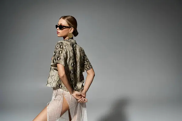 Mulher elegante ostentando óculos de sol e uma camisa de pele de cobra na moda. — Fotografia de Stock