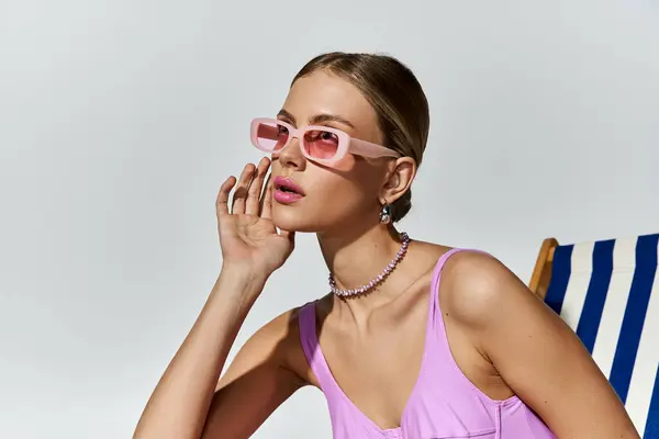 Blonde Frau entspannt im Strandkorb mit trendiger rosa Sonnenbrille. — Stockfoto