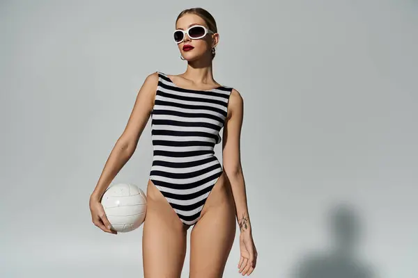 Fashionable woman in black and white stripes plays volleyball. — Stock Photo