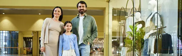 Joyful family, parents and children, walking amidst vibrant shops in a busy shopping mall on a leisurely weekend outing. — Stock Photo
