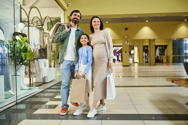A pregnant woman and her young daughter enjoy a leisurely walk in a bustling shopping mall, sharing special moments together. — Stock Photo
