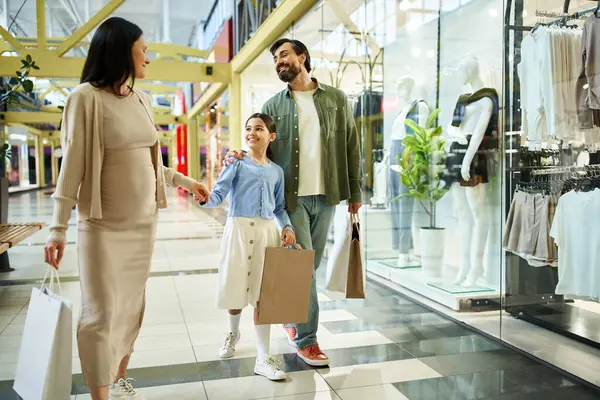 A joyful family explores a shopping mall, browsing and shopping together amidst a bustling environment. — Stock Photo