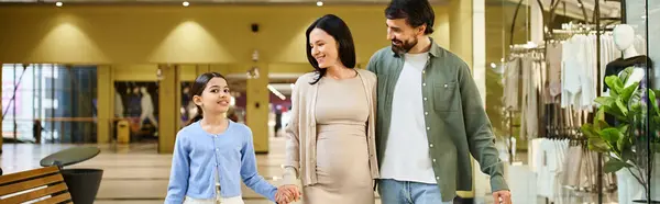 A happy family stroll through a busy and colorful mall on an exciting shopping weekend. — Stock Photo
