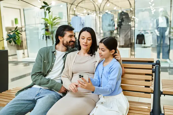 A family of multiple generations sits together on a bench in a bustling shopping mall, enjoying a moment of togetherness. — Stock Photo