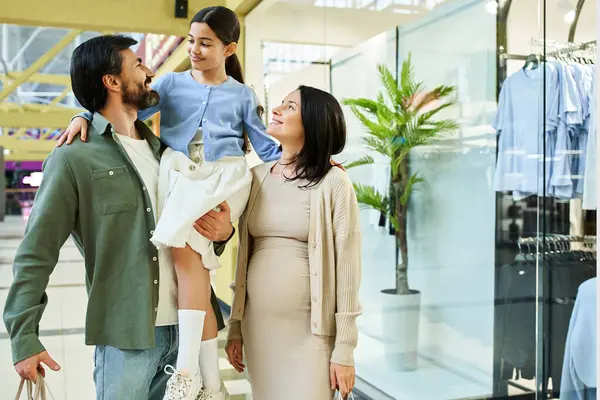 A pregnant woman and her husband happily shop together in a mall, enjoying a weekend outing. — Stock Photo