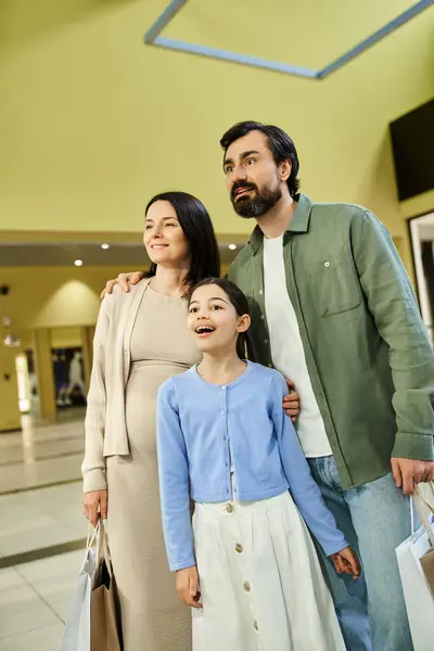 Family enjoying shopping spree, strolling through bustling mall with multiple shopping bags in tow. — Stock Photo