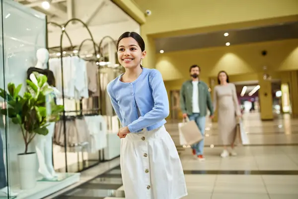 Kid indulges in retail therapy, navigating a bustling shopping mall with her stylish purchases. — Stock Photo