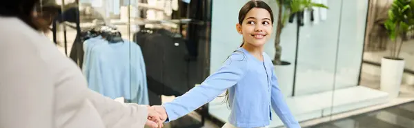 Mãe e filha caminham entusiasticamente em uma loja enquanto fazem compras. — Fotografia de Stock