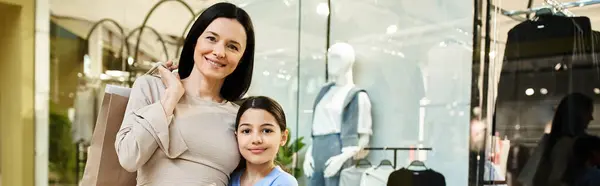 A woman and her daughter enjoy a shopping weekend together, exploring a bustling mall with smiles on their faces. — Stock Photo