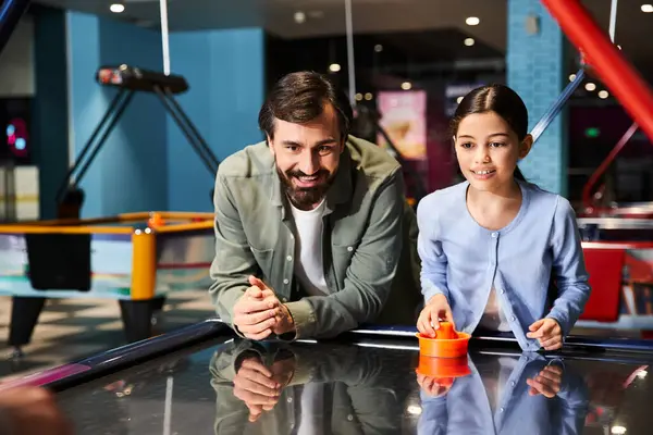 An exciting, fast-paced game of air hockey being played by father and child in a vibrant arcade setting. — Stock Photo