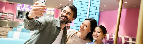 Uma família feliz de quatro gosta de tirar uma selfie na zona de jogos dos shoppings durante um fim de semana cheio de diversão. — Fotografia de Stock