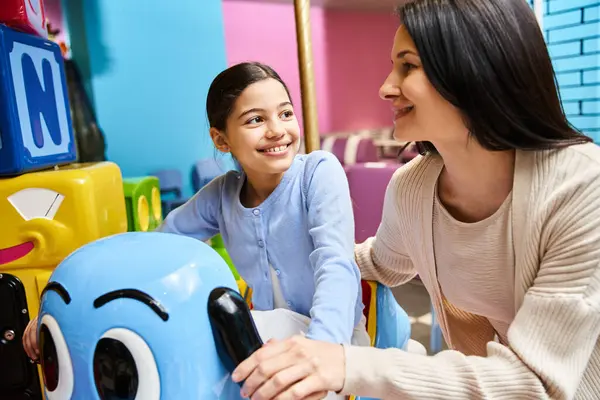 A mother and daughter joyfully engage in play with toys in a bustling toy stores gaming zone on a weekend. — Stock Photo