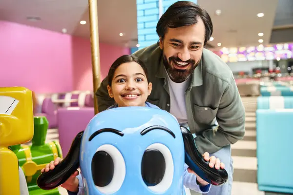 Ein Mann und ein Kind posieren am Wochenende fröhlich neben einem Spielzeugauto in der Spielzone eines Einkaufszentrums. — Stockfoto