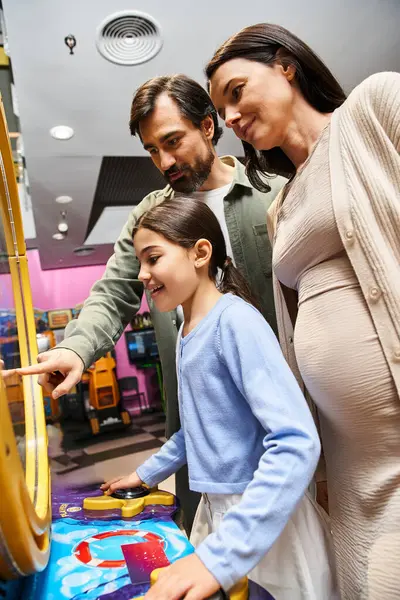 A happy family enjoys gaming together in the malls arcade area during the weekend. — Stock Photo