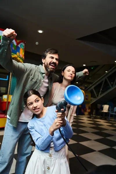 Una familia alegre se reúne, sosteniendo un megáfono y difundiendo alegría durante su excursión de fin de semana. - foto de stock
