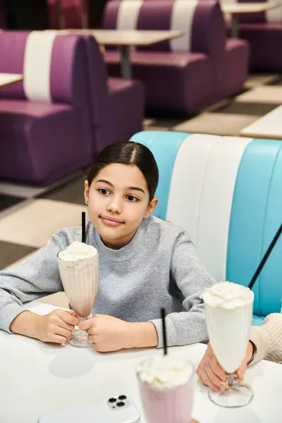 Mother and child happily sip milkshakes at a table in a modern setting, enjoying quality family time during the weekend. — Stock Photo
