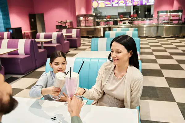 Famiglia seduta insieme al tavolo di un ristorante, godendo di un pasto e trascorrere del tempo di qualità insieme durante il fine settimana. — Foto stock