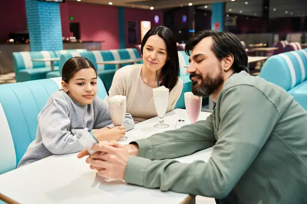A cheerful family enjoys a meal together in a stylish restaurant, creating lasting memories of togetherness and joy. — Stock Photo