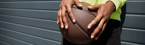 Афроамериканец в модном костюме, держит баскетбол. — стоковое фото