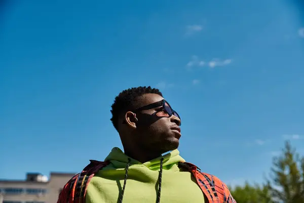 Красивий афроамериканський чоловік в зеленому светрі дивиться вгору в небо. — стокове фото