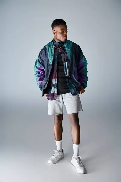 Handsome man in stylish jacket and shorts striking a confident pose. — Stock Photo
