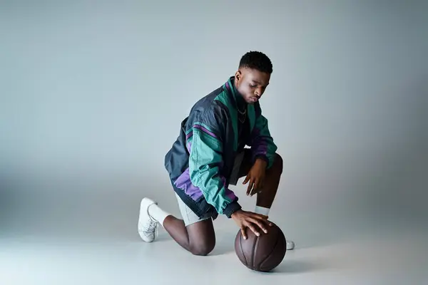 Elegante jovem afro-americano em trajes elegantes agachado com basquete. — Fotografia de Stock