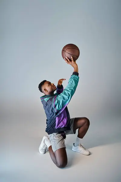 A stylish African American basketball player crouches to catch the ball. — Stock Photo