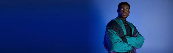 Handsome man cross arms before blue backdrop — Stock Photo