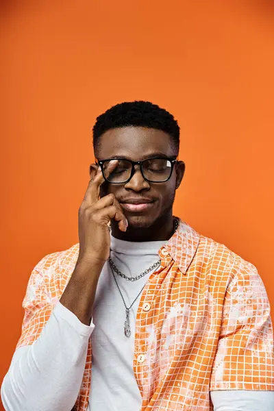 A fashionable young African American man wearing glasses and an orange shirt. — Stock Photo