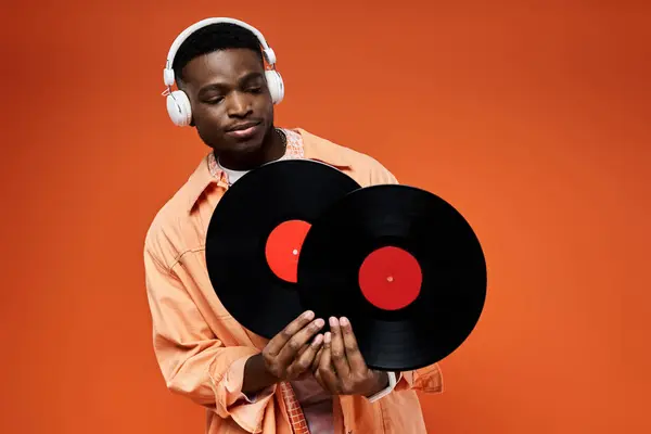 Elegante hombre negro con auriculares sosteniendo un registro. - foto de stock